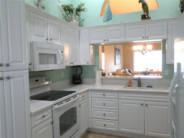 a kitchen with cabinets appliances a sink and a window