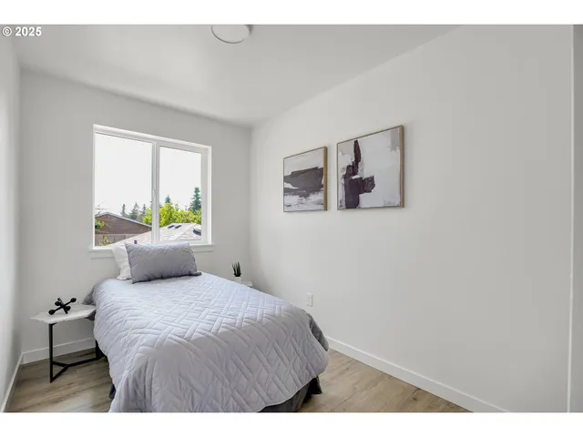a bedroom with a bed and painting on the wall