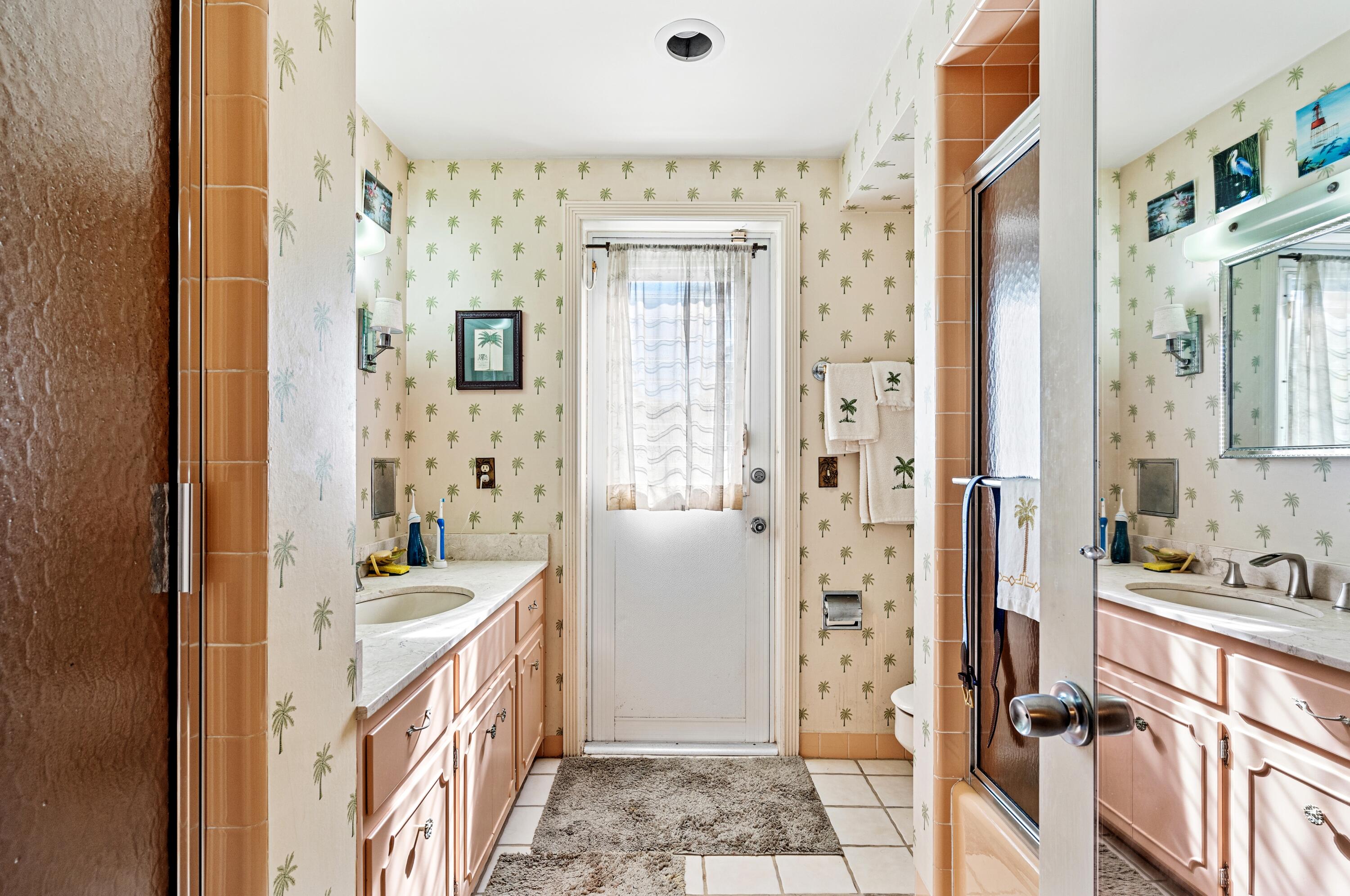 3224 North Ocean Boulevard Gulf Stream, FL 33483 - Photo 34 of 48 a bathroom with a double vanity sink a mirror a bathtub and shower