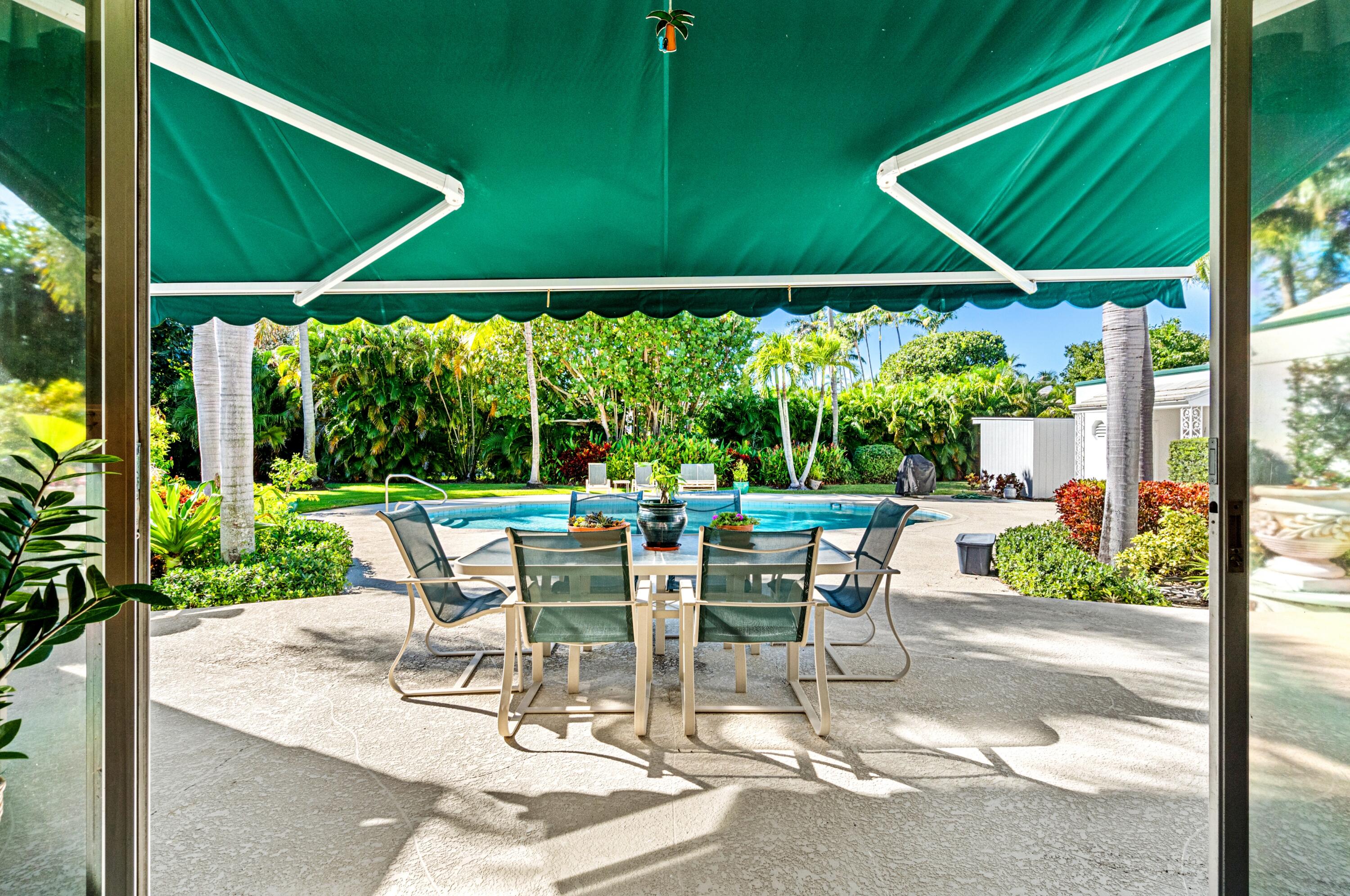3224 North Ocean Boulevard Gulf Stream, FL 33483 - Photo 35 of 48 a view of a patio with table and chairs potted plants with floor to ceiling window yard