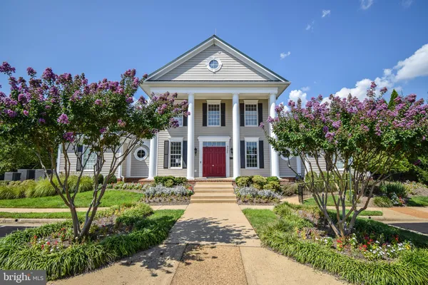 a living room with furniture a fireplace and large windows