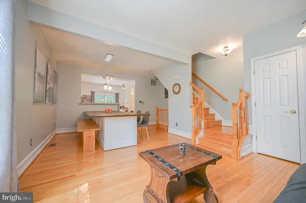 a kitchen with a refrigerator stainless steel appliances wooden floor and a window