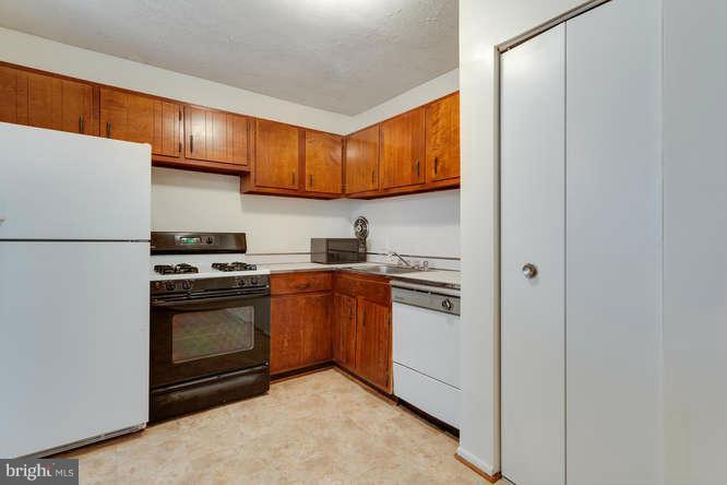 5049 7th Road South, Unit 302 Arlington, VA 22204 - Photo 17 of 26 a kitchen with stainless steel appliances granite countertop a stove a refrigerator and a sink