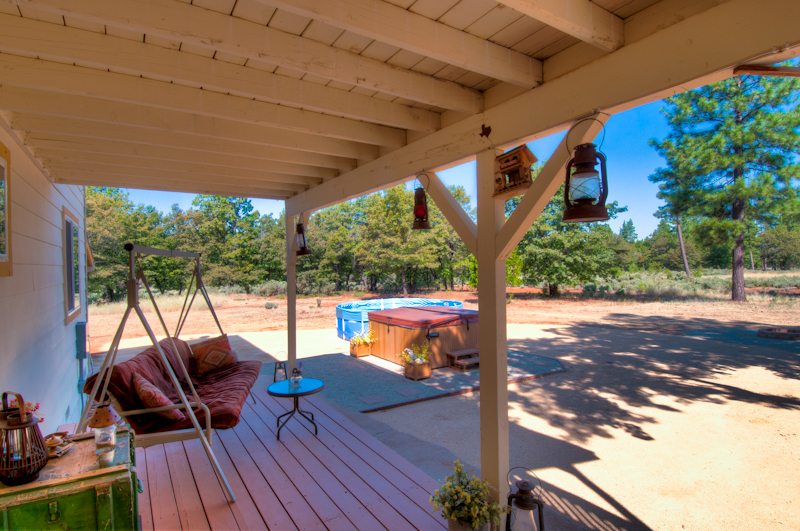 10672 Ridgetop Road Whitmore, CA 96096 - Photo 3 of 20 a patio with wooden floor a yard a table and chairs