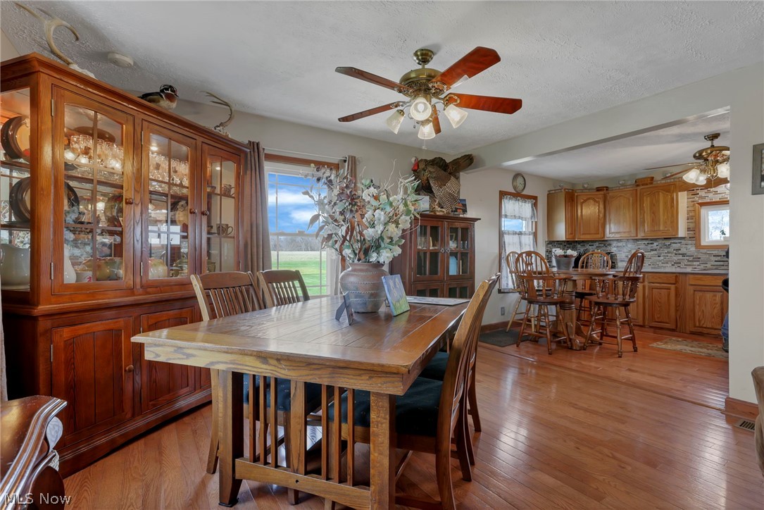 5502 Dutch Ridge Road New Straitsville, OH 43766 - Photo 17 of 49 Dining space featuring light wood-style floors, ceiling fan, plenty of natural light, and a textured ceiling