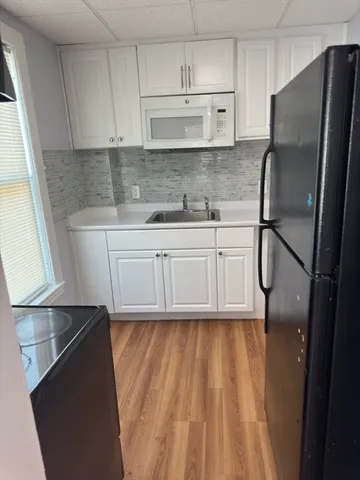a kitchen with a refrigerator a sink and cabinets