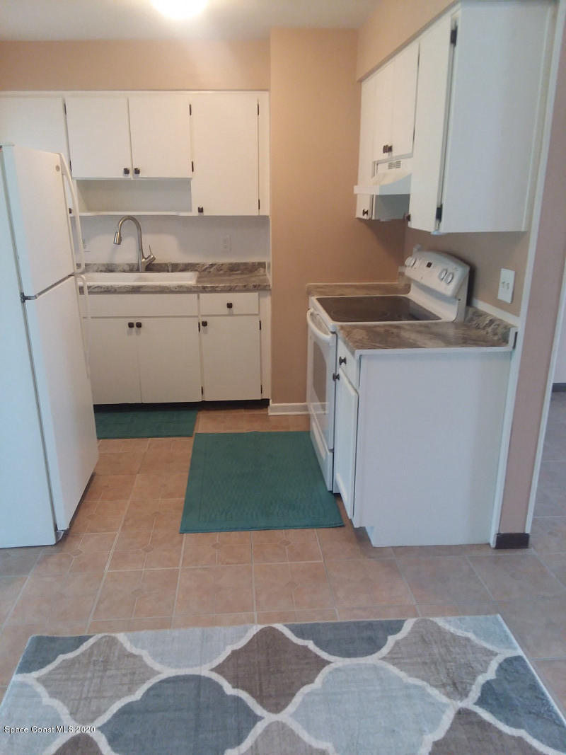 1030 Hibiscus Street Cocoa, FL 32927 - Photo 3 of 6 a kitchen with granite countertop a sink stove and cabinets