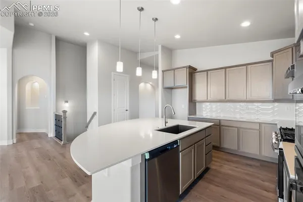 a kitchen that has a sink a stove and chairs in it