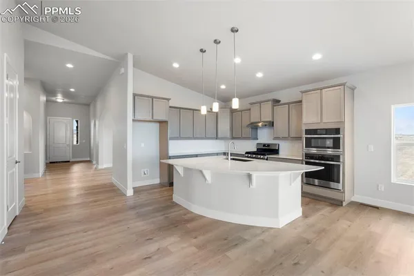 a view of kitchen with stainless steel appliances granite countertop a stove top oven a sink and a refrigerator