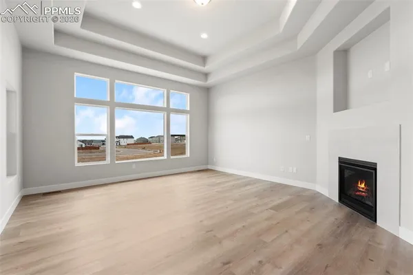 a view of an empty room with a fireplace and a window