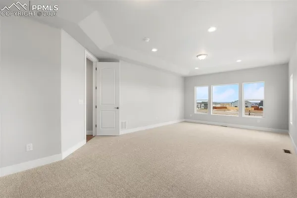 a view of a big room with windows and chandelier fan
