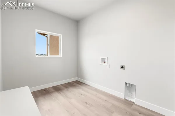 a view of a small space with wooden floor and a window