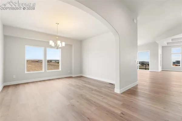 a view of a livingroom with wooden floor and a kitchen
