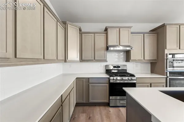 a kitchen with a sink stove top oven and cabinets