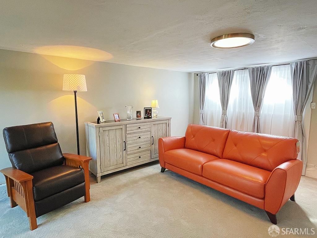 3231 Fernside Boulevard Alameda, CA 94501 - Photo 25 of 38 a blue couch sitting in a living room next to a lamp