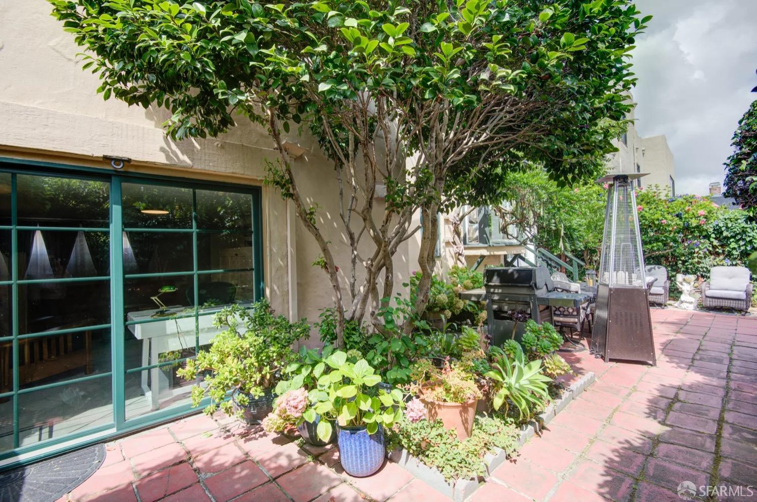 3231 Fernside Boulevard Alameda, CA 94501 - Photo 34 of 38 a backyard of a house with a table and chairs potted plants and large tree