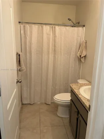a bathroom with a granite countertop sink toilet and a mirror
