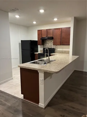 a kitchen with stainless steel appliances granite countertop a sink counter space and wooden floor
