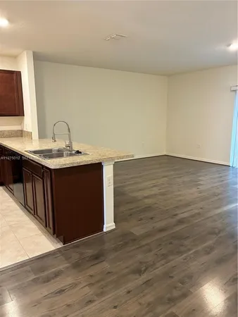 a kitchen with stainless steel appliances granite countertop a refrigerator a sink a stove a microwave and wooden cabinets