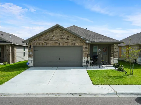 a front view of a house with a yard and garage