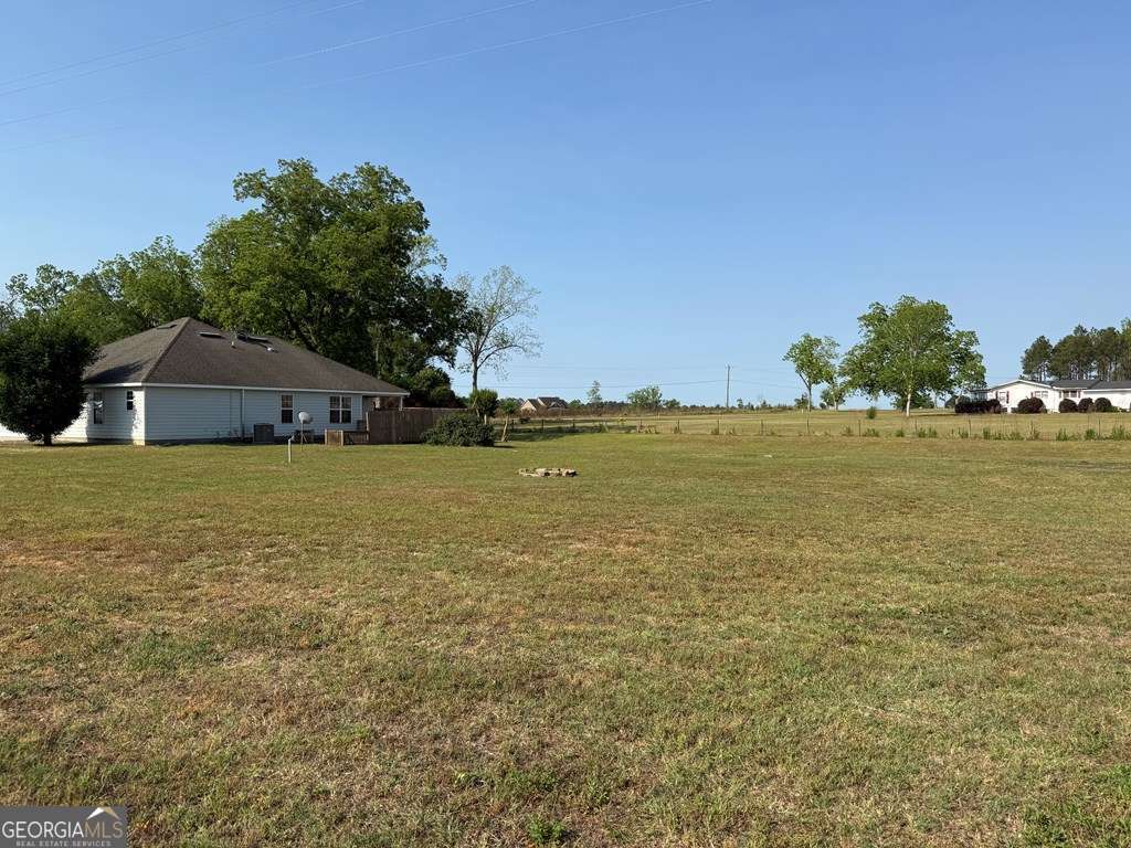 3749 Old Pine Road Valdosta, GA 31605 - Photo 22 of 24 a blue swimming pool is sitting in middle of the water next to a yard