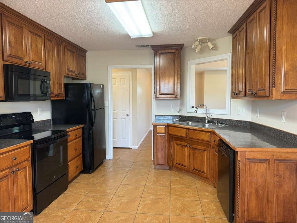 3749 Old Pine Road Valdosta, GA 31605 - Photo 6 of 24 a kitchen with stainless steel appliances granite countertop a refrigerator stove top oven and sink