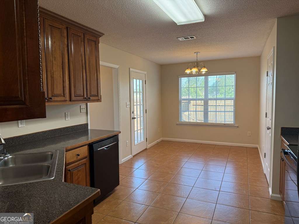 3749 Old Pine Road Valdosta, GA 31605 - Photo 7 of 24 a kitchen with granite countertop a stove a sink and a refrigerator
