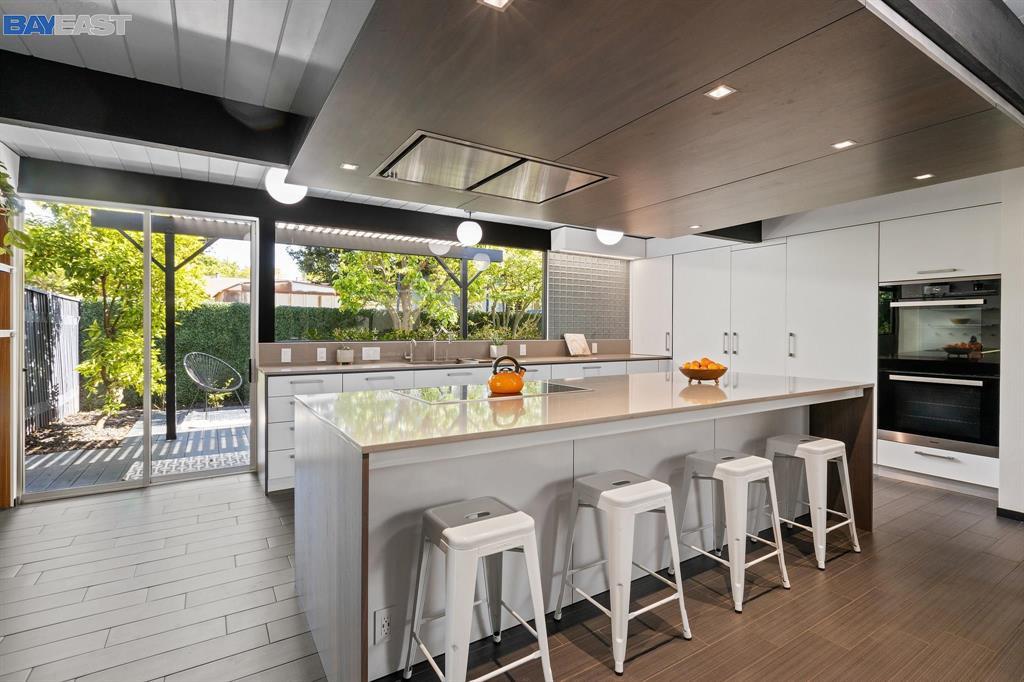 252 Clyde Drive Walnut Creek, CA 94598 - Photo 21 of 57 a kitchen with stainless steel appliances granite countertop a stove and white cabinets with wooden floor