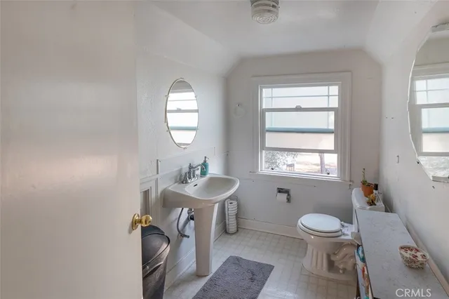 a bathroom with a toilet a sink and mirror