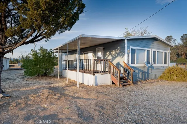 a view of a house with a wooden roof and a bench