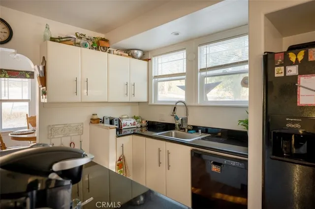 a kitchen with granite countertop a sink stove and cabinets