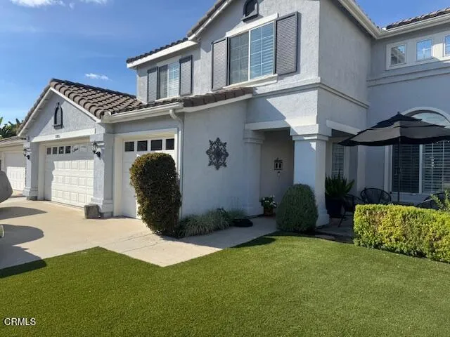 a view of a house with backyard and a tree