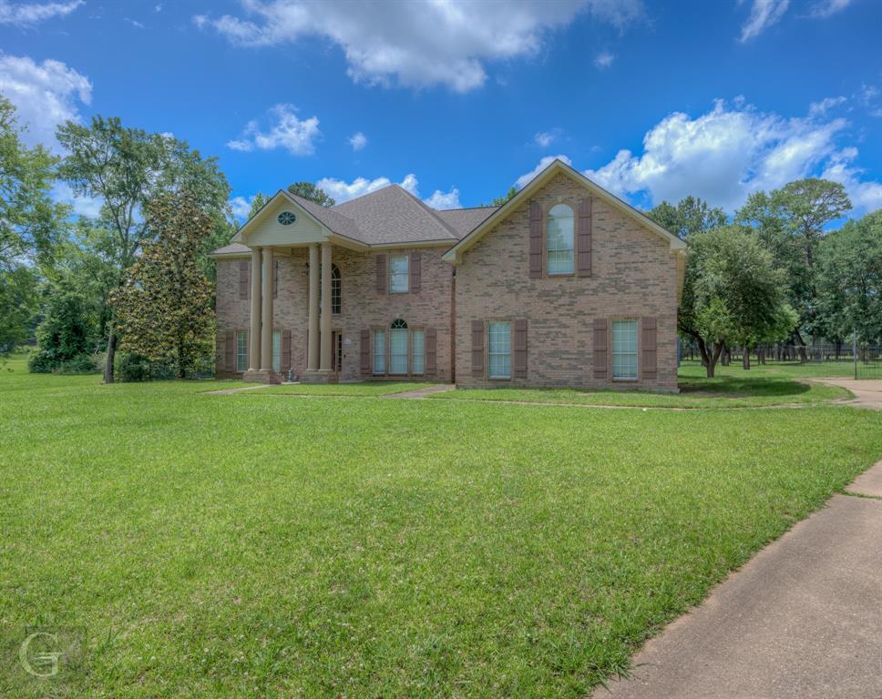 a front view of a house with yard and green space