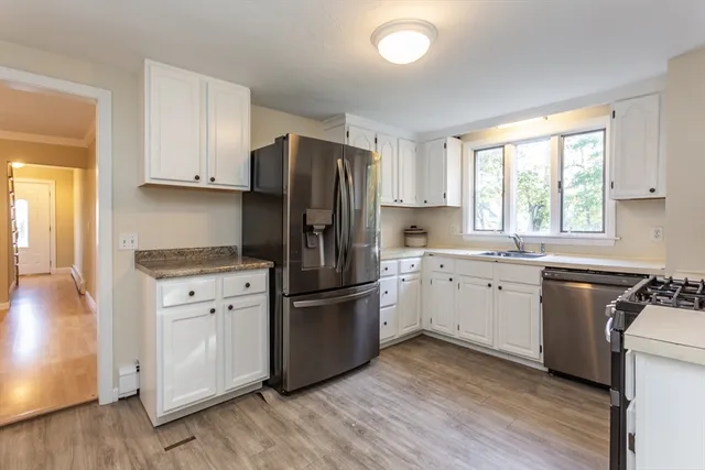 a kitchen with a refrigerator stove top oven and sink