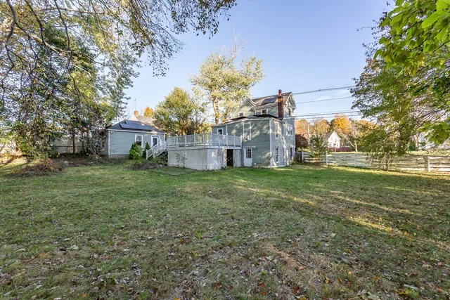 a view of a house with wooden deck and a yard