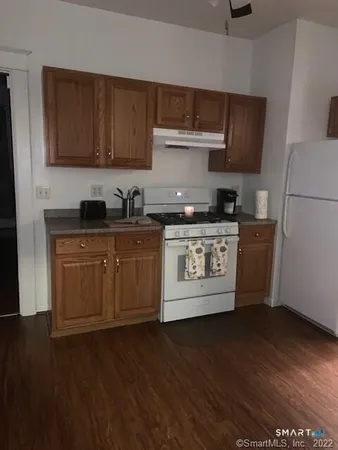 a kitchen with stainless steel appliances granite countertop a stove a sink dishwasher and a microwave with wooden floor