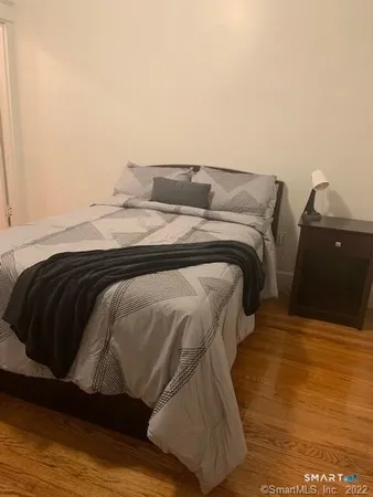 a bedroom with a bed and wooden floor