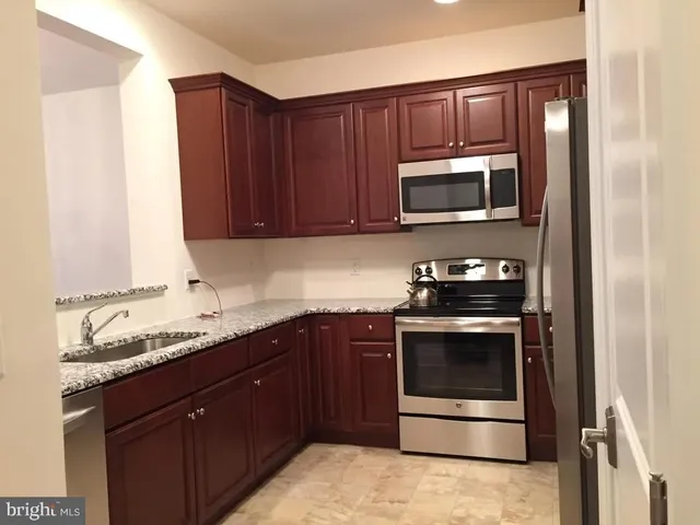 a kitchen with granite countertop stainless steel appliances and cabinets