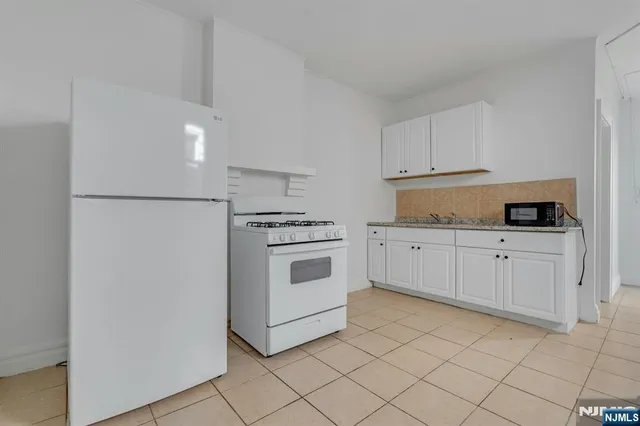 a kitchen with white cabinets and white appliances