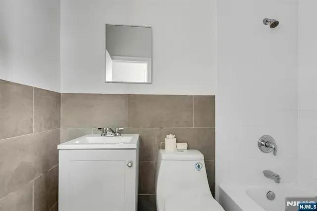a bathroom with a bathtub sink and mirror
