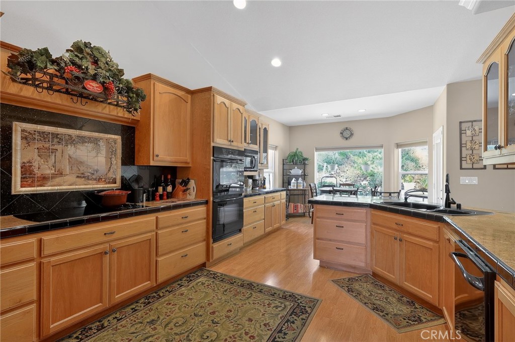 19370 Park Ridge Drive Hidden Valley Lake, CA 95467 - Photo 30 of 61 a kitchen with stainless steel appliances kitchen island granite countertop a stove a sink dishwasher and cabinets with wooden floor