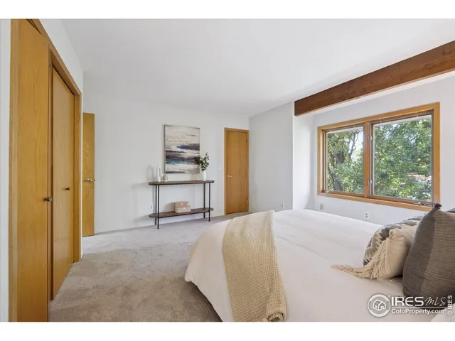 a spacious bedroom with a bed and a large window