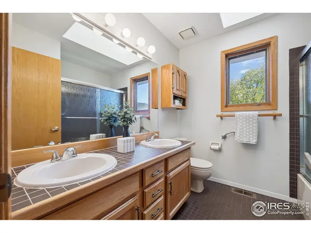 a bathroom with a sink double vanity granite and a toilet