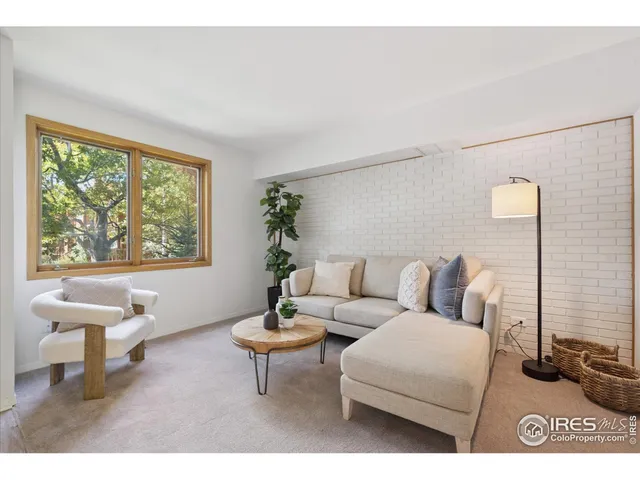 a living room with furniture a table and a large window