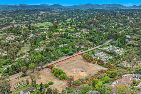 an aerial view of a house with a yard and mountain view in back