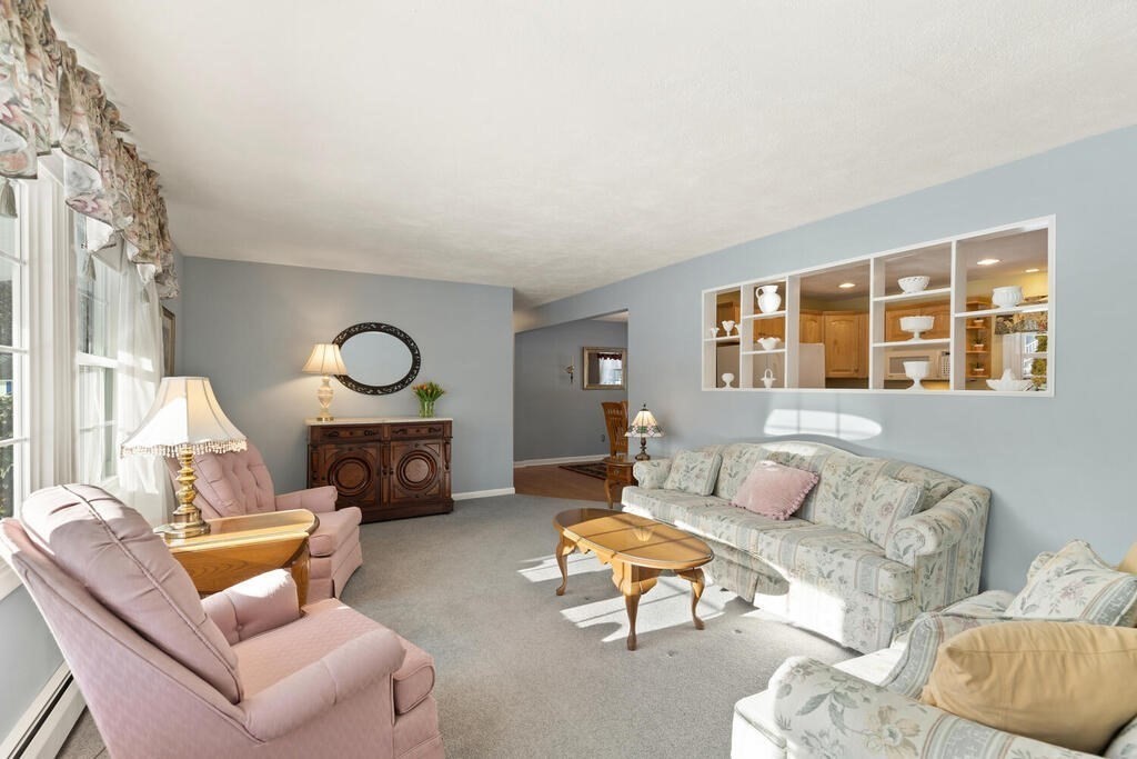 23 Walker Road Beverly, MA 01915 - Photo 5 of 33 a living room with furniture a fireplace and a large window with garden view