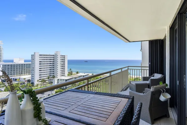 a balcony with wooden floor and outdoor seating