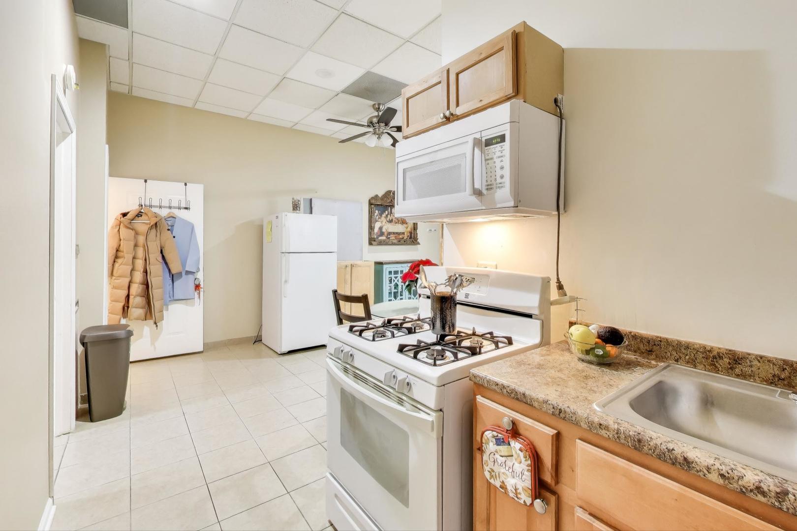 4346 North Pulaski Road, Unit C Chicago, IL 60641 - Photo 9 of 20 a kitchen with a sink stove and refrigerator