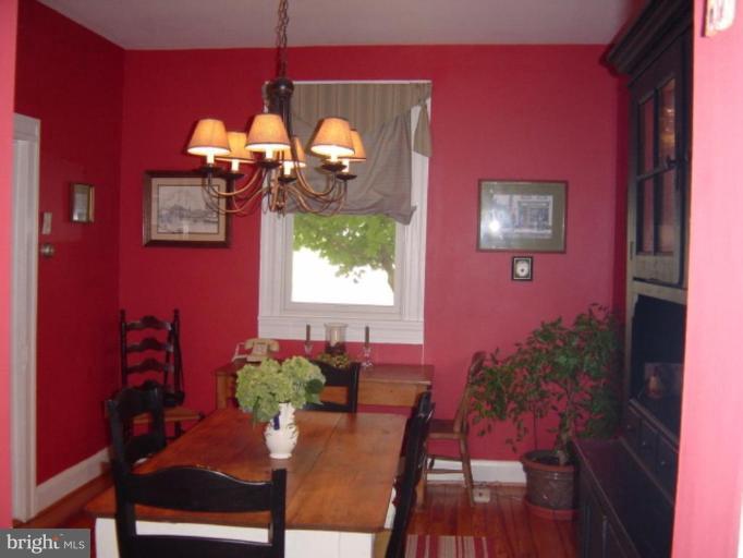 6508 Banbury Road Baltimore, MD 21239 - Photo 6 of 26 a dining room with furniture potted plants and wooden floor