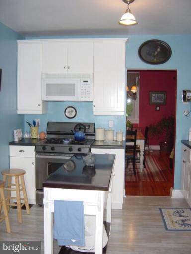 6508 Banbury Road Baltimore, MD 21239 - Photo 7 of 26 a kitchen with kitchen island a stove cabinets and wooden floor